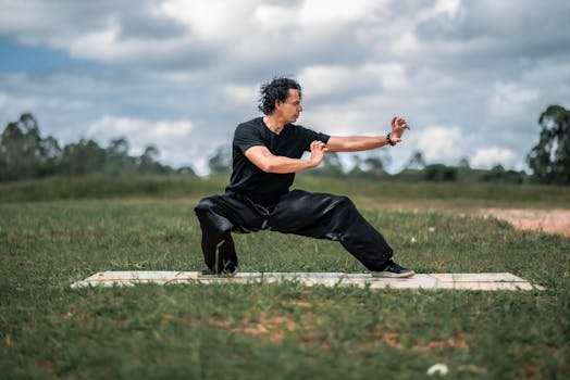 Man performing tai chi in a peaceful outdoor setting, focusing on balance and mindfulness.